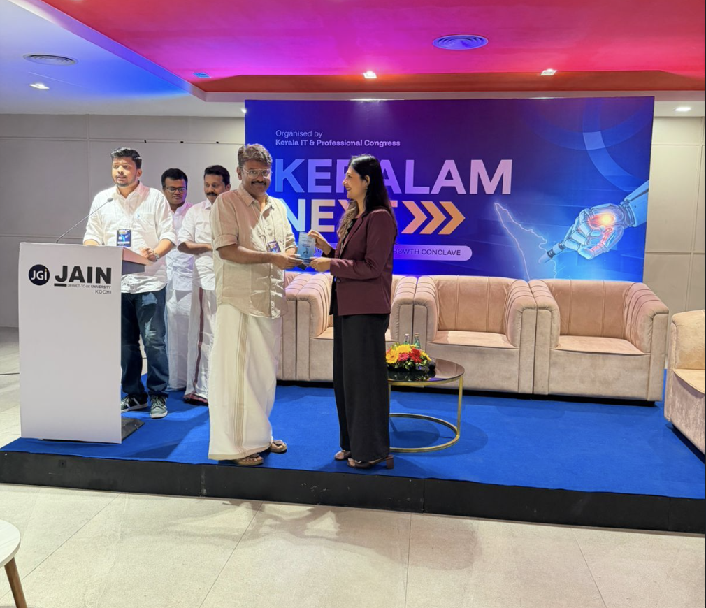 StartinKerala representative presenting a memento on stage at Keralam Next