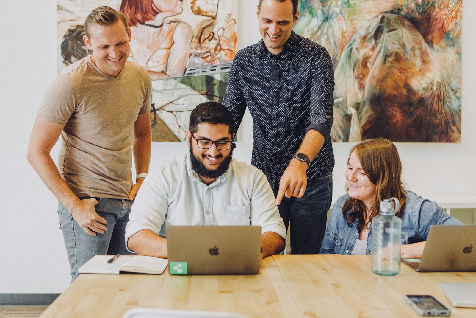 Coworkers collaborating around a laptop
